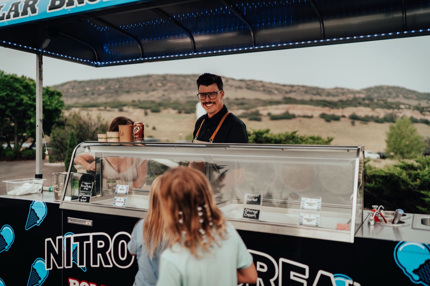 Chef Chuck James smiling behind the Polar Bros nitro ice cream cart
