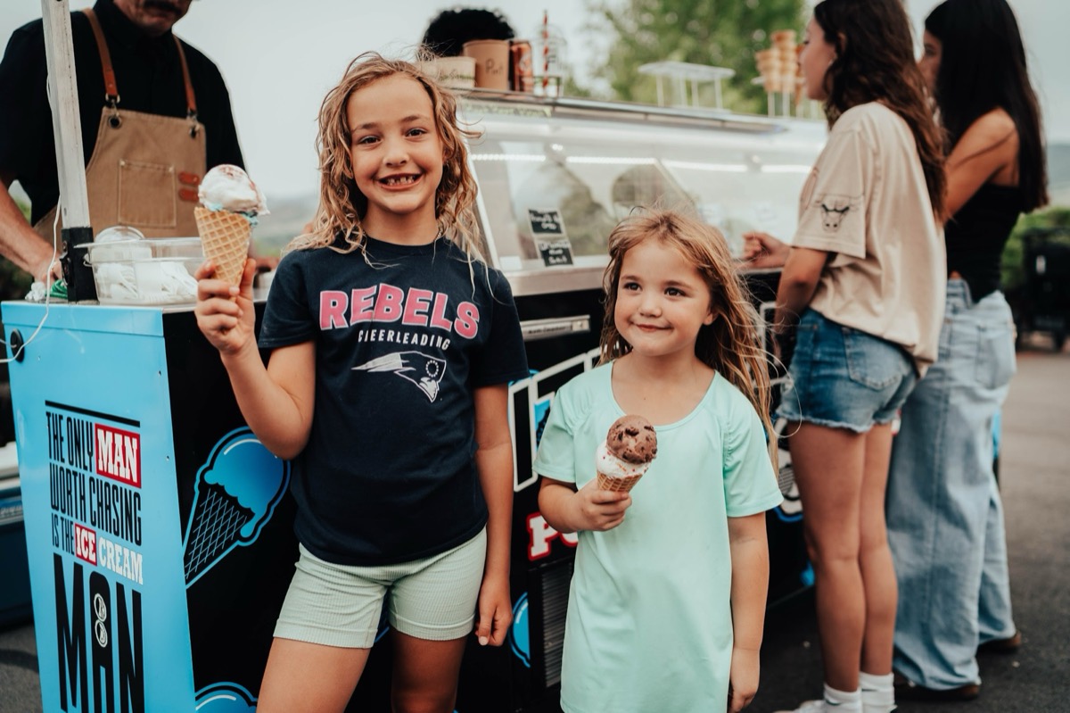 Two kids grinning with fresh waffle cones at a Polar Bros event