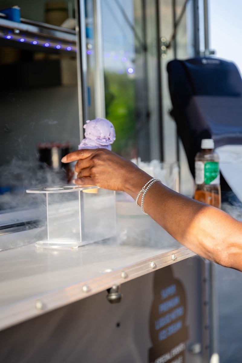 A guest reaching for a scoop of lavender nitro ice cream