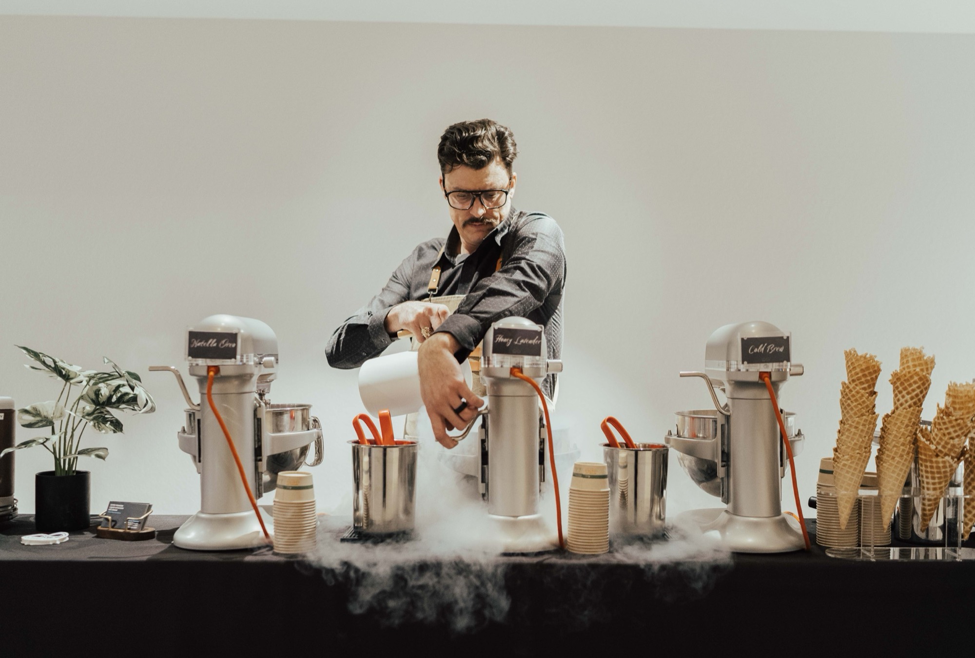 Chef Chuck James pouring liquid nitrogen into stand mixers, fog billowing across the table